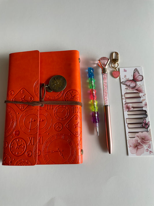 Aesthetic burnt orange A6 bookish journal set featuring embossed vintage clock notebook, crystal pen and heart keychain