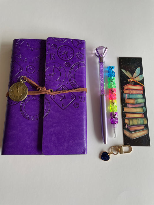 Aesthetic violet bookish gift box featuring embossed A5 journal, crystal pen, bookmark and decorative keychain
The deep violet embossed cover with vintage clock details makes this set truly unique